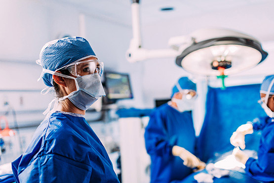 Two doctors operating and one doctor looking 